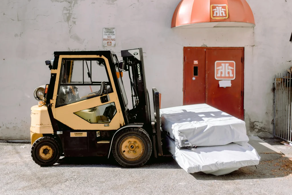 Forklift sales in Calgary showcased with a forklift delivering wrapped pallets at a loading dock
